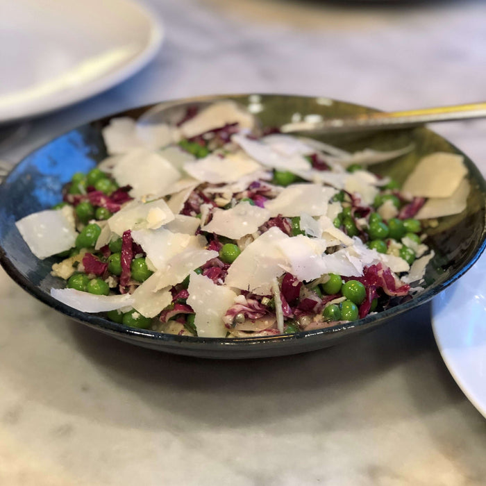 Delicious Pea, Radicchio Fennel, Parm Salad Recipe served in a bowl with greens and shaved cheese.