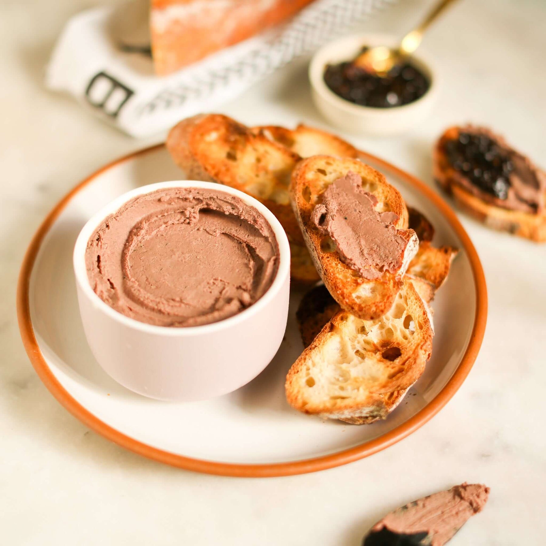 Delicious chicken liver mousse recipe served with toasted bread on a plate.