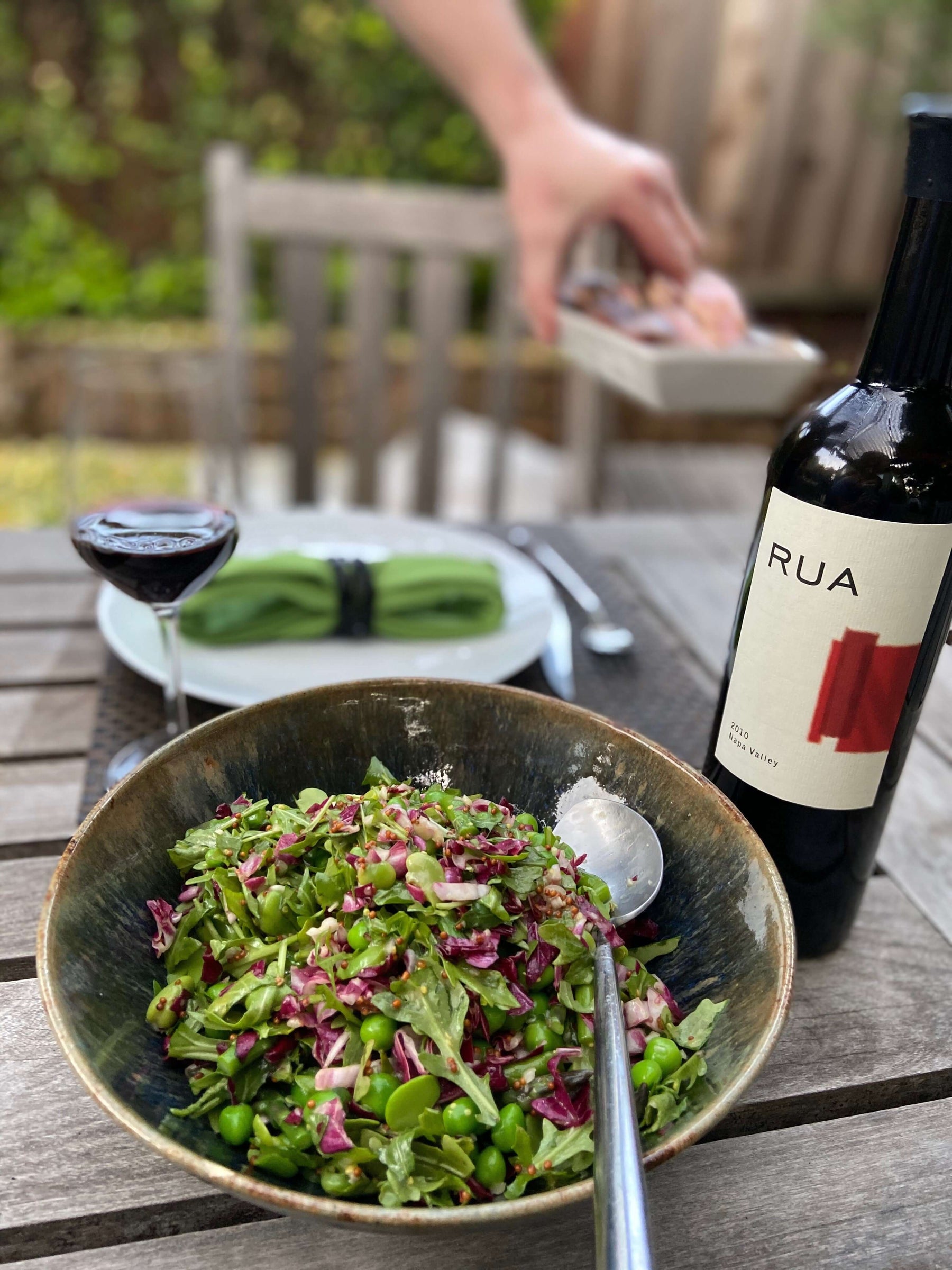 Delicious Our Favorite Spring Salad Recipe in a bowl with wine and table setting.