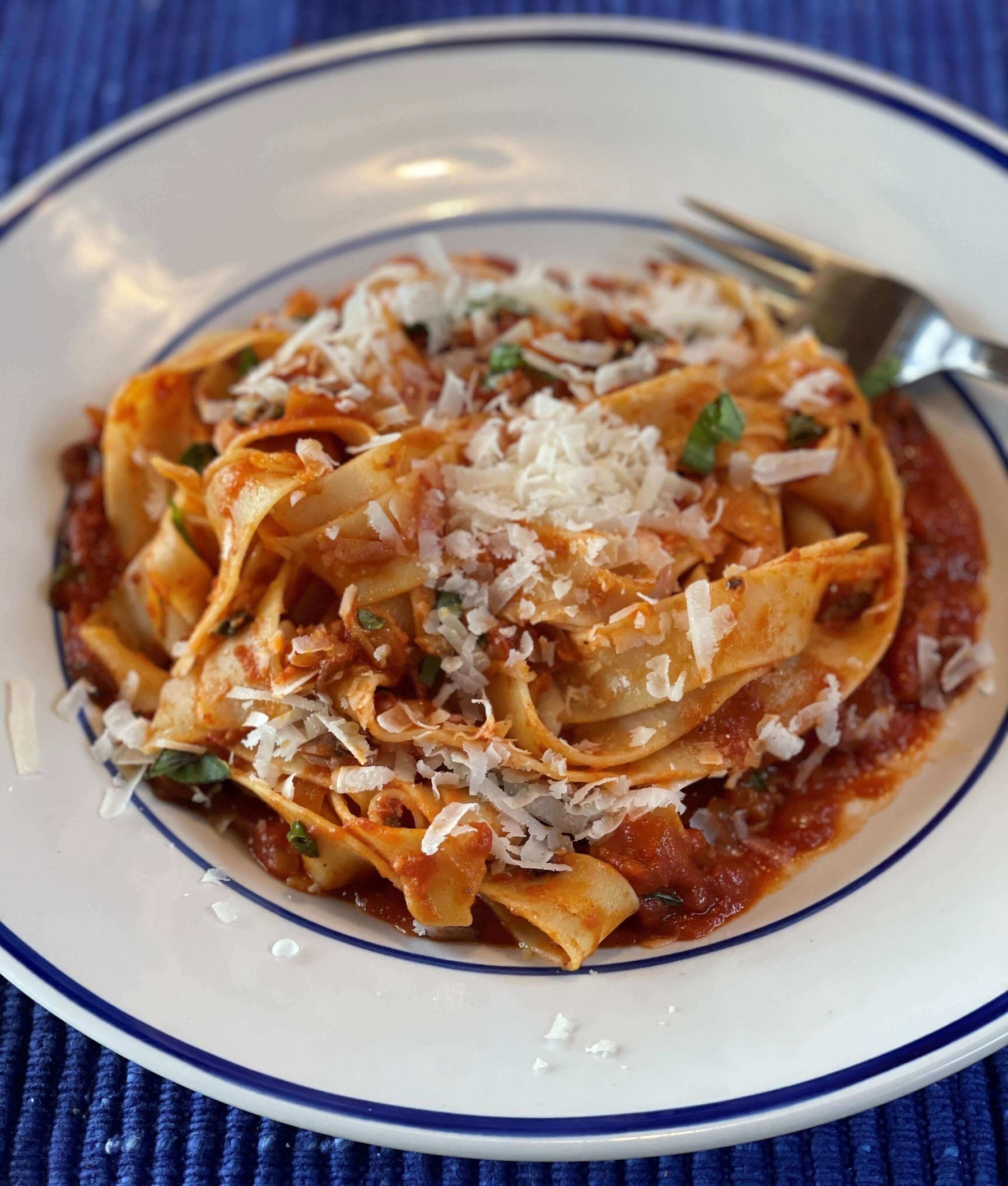 Delicious vegan vegetable bolognese recipe served with pasta and topped with grated cheese.