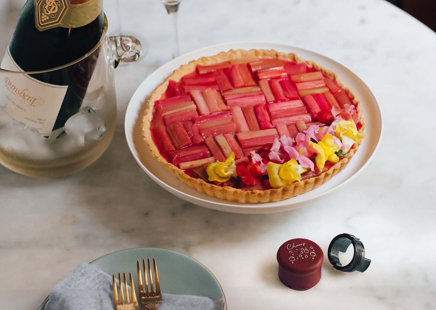 Rhubarb lemon tart recipe beautifully presented with flowers and served with champagne.