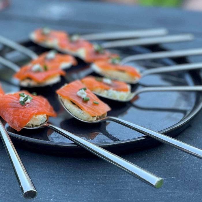 Plate of Smoked Salmon Spoons Recipe garnished with chives on stainless-steel spoons.