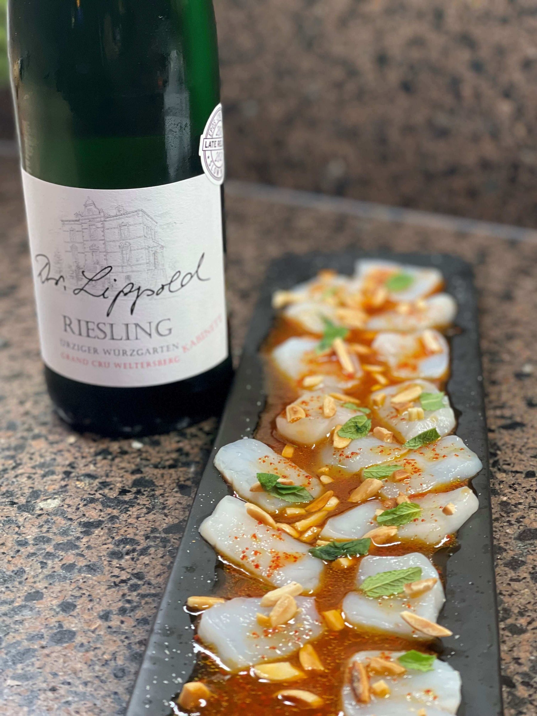 Scallop Crudo Recipe featuring fresh scallops garnished with almonds and paired with Riesling wine.
