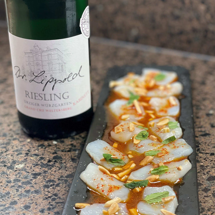 Scallop Crudo Recipe featuring fresh scallops garnished with almonds and paired with Riesling wine.