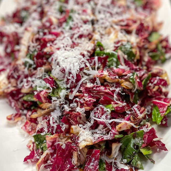 Winter Radicchio Salad with Balsamic Drizzle Recipe served on a white platter, topped with cheese.