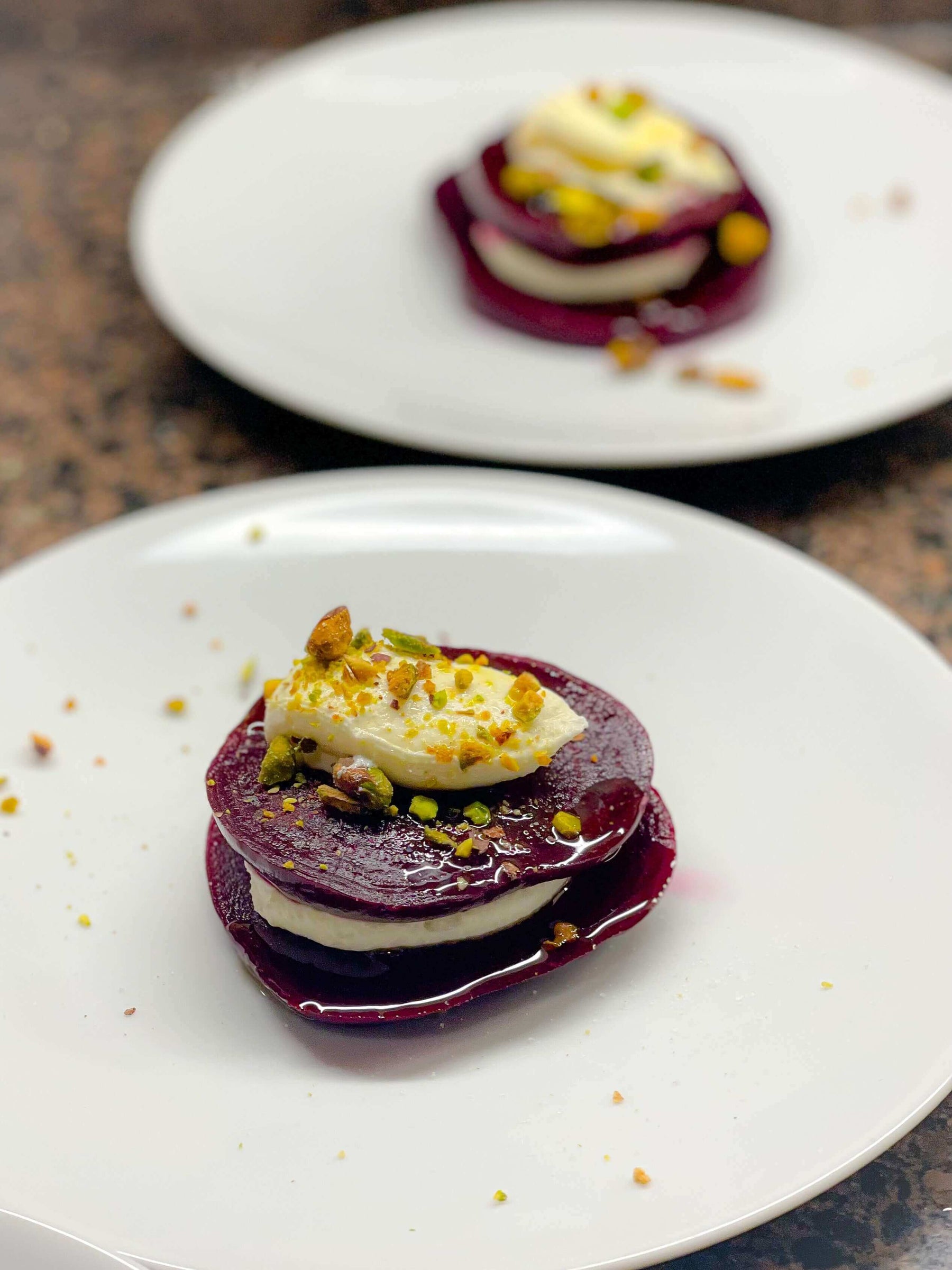 Roasted Beets with Meyer Lemon Whipped Ricotta and Pistachios Recipe served on white plates, garnished with pistachios.