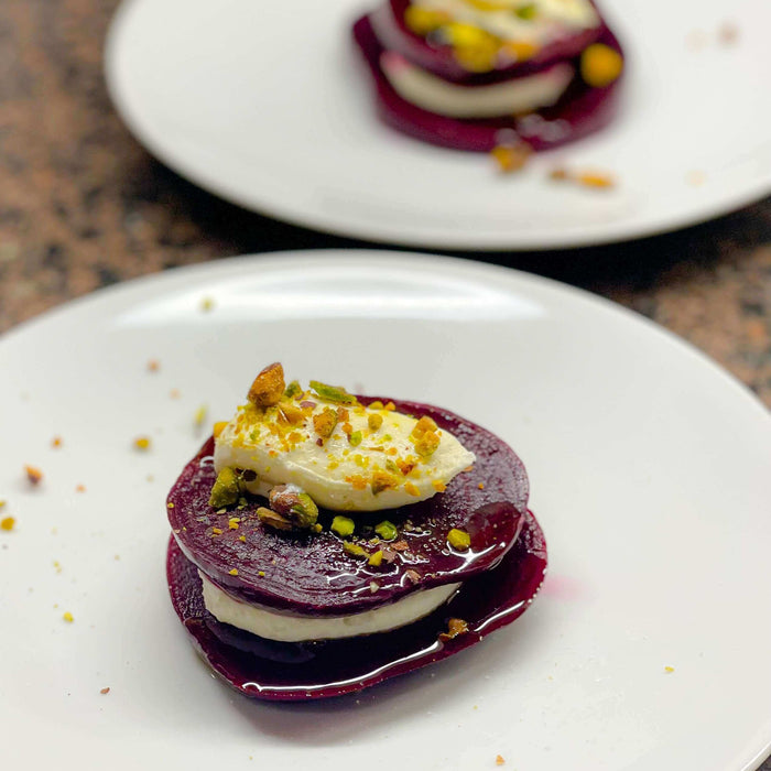 Roasted Beets with Meyer Lemon Whipped Ricotta and Pistachios Recipe served on white plates, garnished with pistachios.