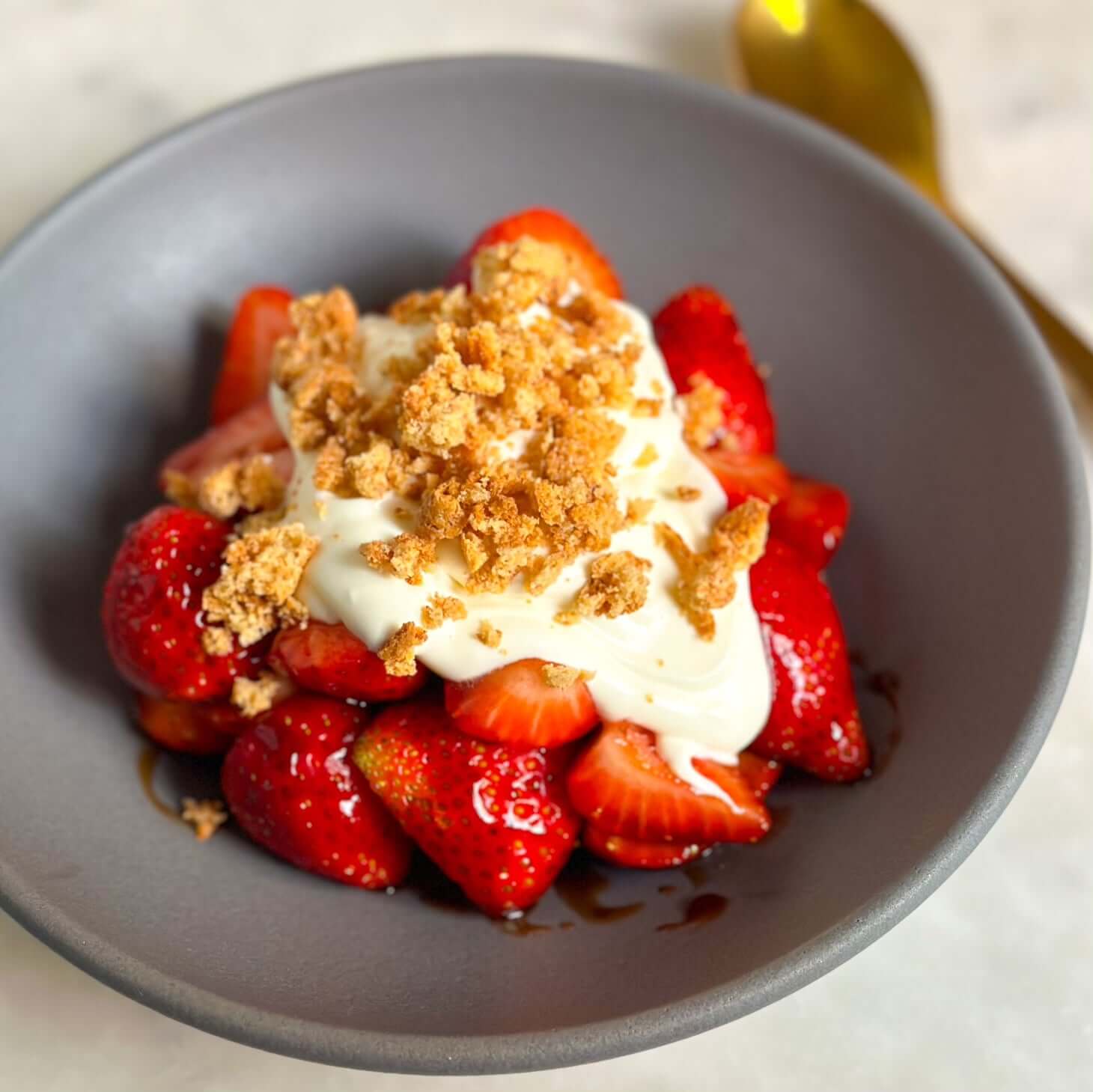 Delicious bowl of Strawberries, Mascarpone Cream and Crumbled Amaretti Cookies Recipe topped with crumbled cookies.
