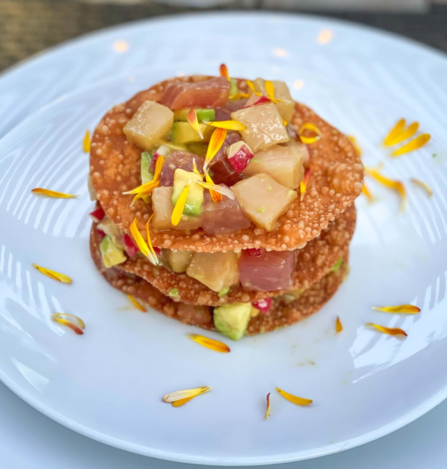 Ahi/Hamachi Napoleon Recipe served in a delightful presentation with colorful toppings.