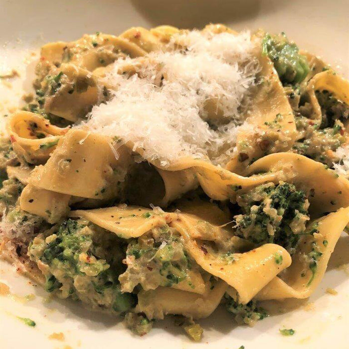 Delicious Pasta Con Broccoli Recipe featuring pappardelle and topped with grated cheese.