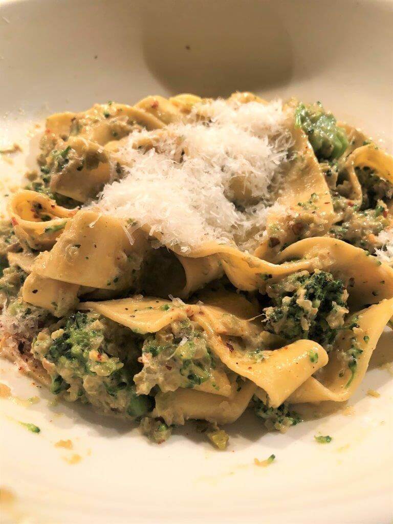 Delicious Pasta Con Broccoli Recipe featuring pappardelle and topped with grated cheese.