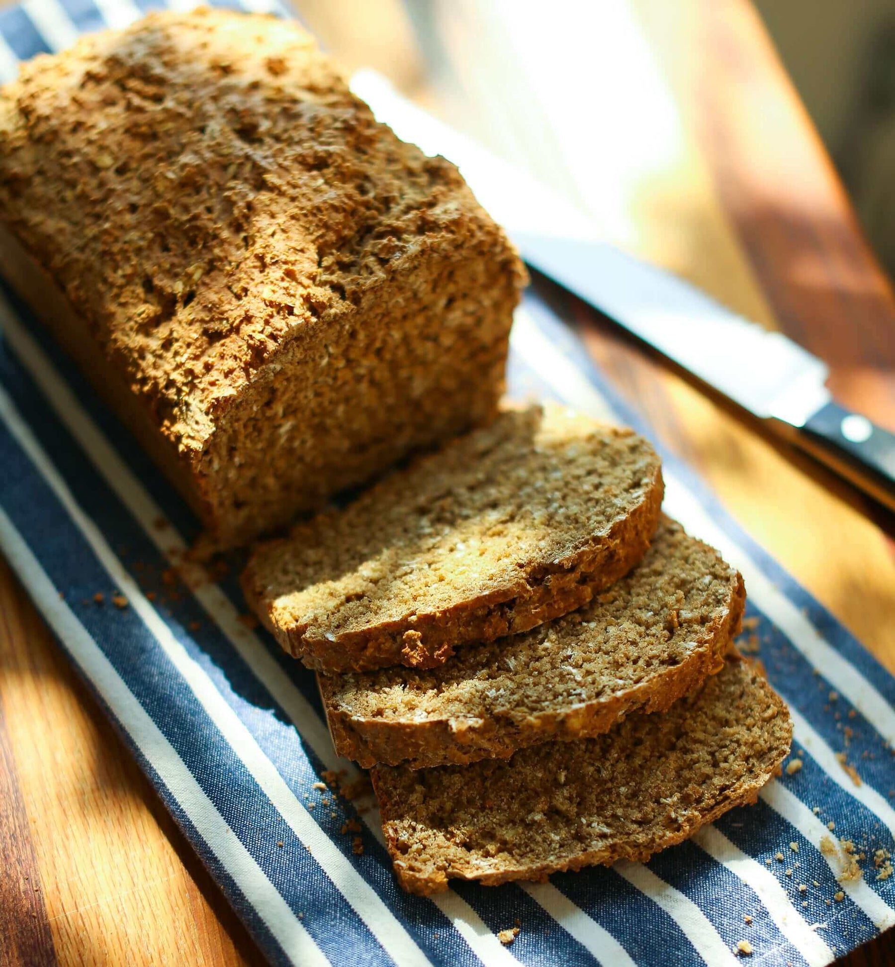 Freshly baked Irish Wheaten Bread Recipe served with sliced pieces on a striped cloth.