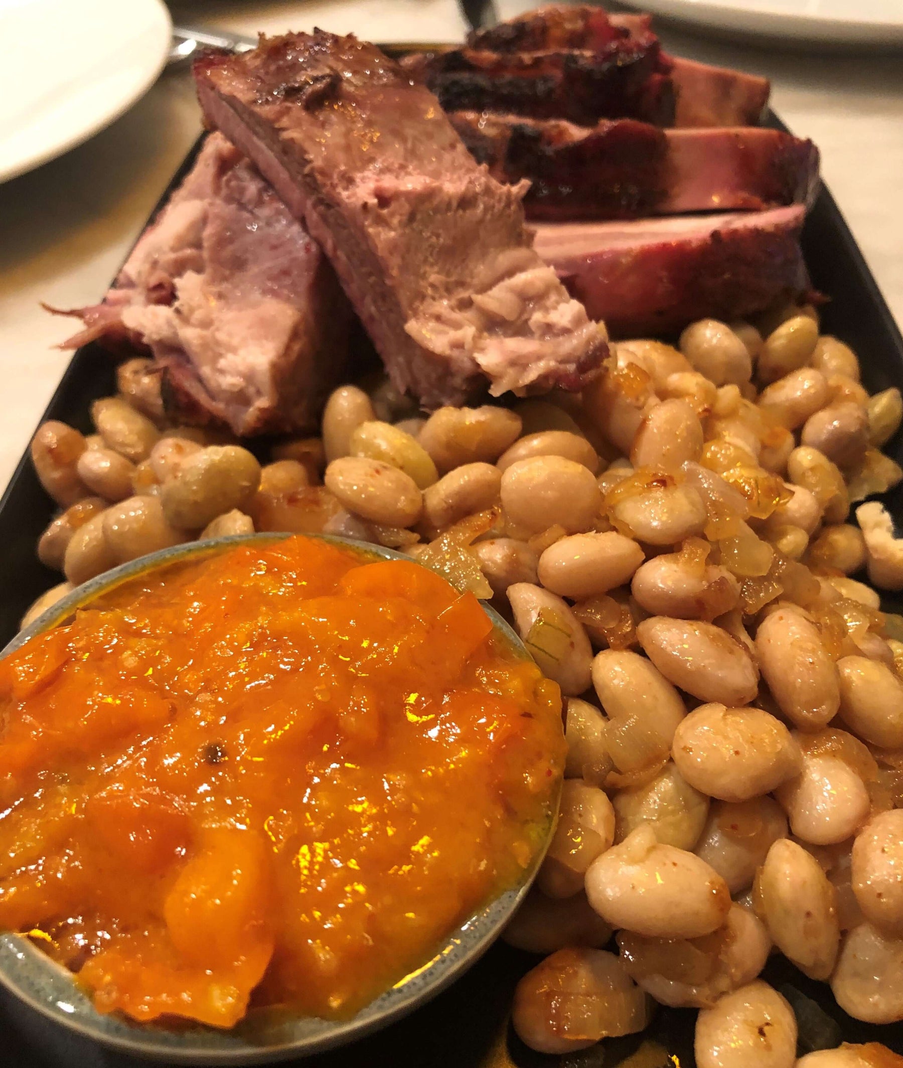 Pork, Beans and Tomato Jam Recipe featuring tender pork, beans, and a vibrant tomato jam on a platter.