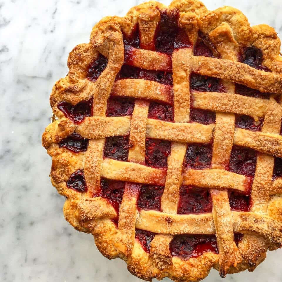 Easy cherry pie recipe with a golden lattice crust and rich cherry filling on a marble surface.