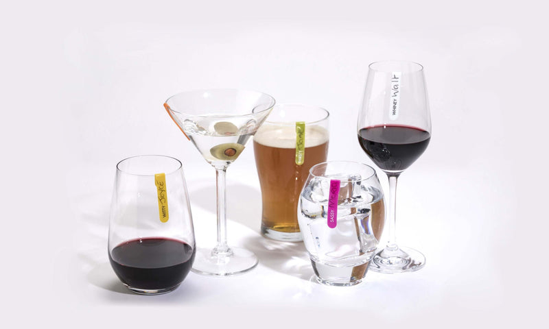 Colorful mini silicone identifiers on various stemless glasses filled with drinks.