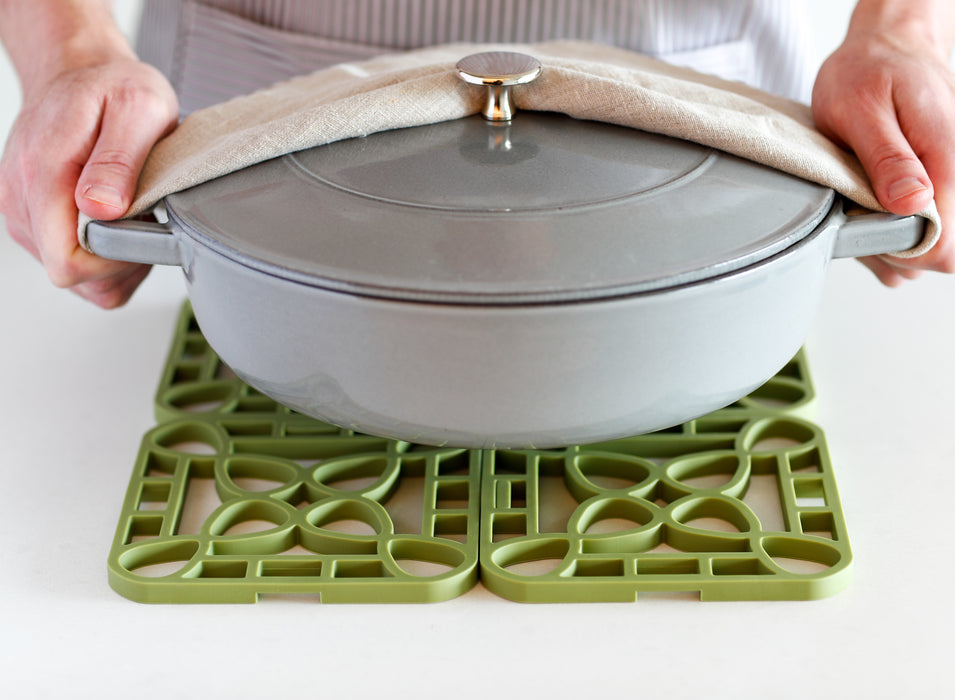 Interlocking silicone trivet under a heavy pot, providing heat-resistant support and stylish kitchen protection.
