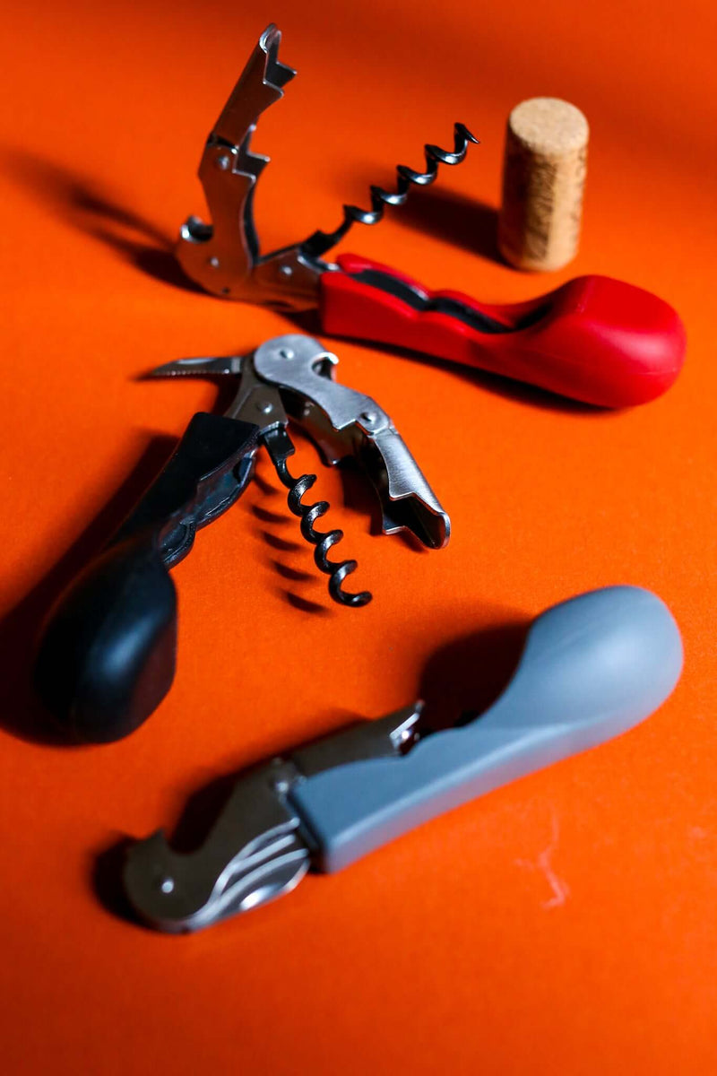 Silicone handled corkscrews by CapaBunga in red, black, and gray with wine cork.