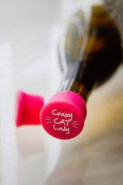 Crazy Cat Lady silicone wine cap in bright pink on a wine bottle, perfect for cat lovers who enjoy wine.