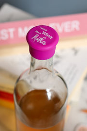 Silicone wine cap that says 'I Drink Wine Like a Mother' on a bottle of wine.