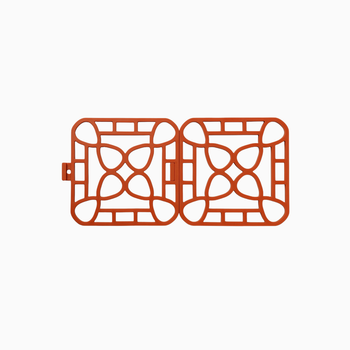 Interlocking silicone trivet featuring a unique modular design and heat-resistant properties, shown in vibrant orange color.