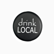 Black silicone wine cap with the phrase 'drink LOCAL' designed for wine enthusiasts.