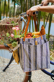 Striped market tote with pockets, stylish design and sturdy handles draped over a bicycle