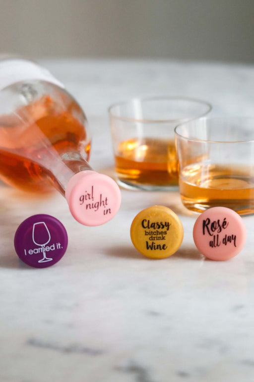 Sip Squad Silicone Wine Cap Set with fun phrases on colorful caps and glasses of wine, perfect for gatherings or self-care.