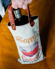 Happy Camper Canvas Wine Tote with vegan leather handles, holding a bottle, perfect for gifts and outdoor adventures.