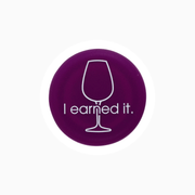 Purple silicone wine cap with the phrase 'I earned it.' featuring a wine glass illustration.