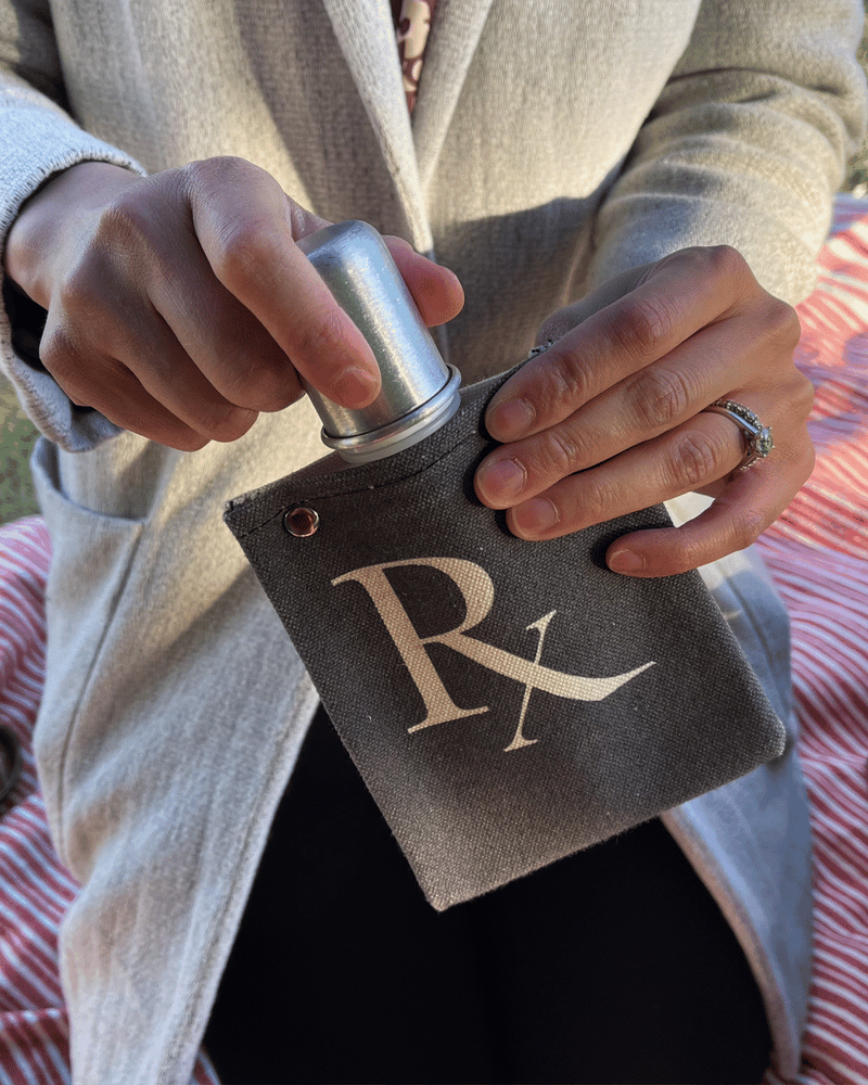 Person holding an RX 120ml canvas flask with a silver bottle, showcasing its stylish design and functionality.