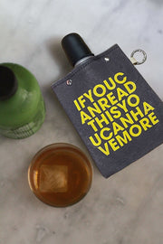 Ifyoucanread 240ml flask with cotton canvas cover next to a green beverage bottle and a glass of drink on a marble surface.