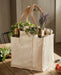Deluxe Multi-Pocketed Canvas Market Tote with Genuine Leather filled with wine and herbs on a kitchen table.