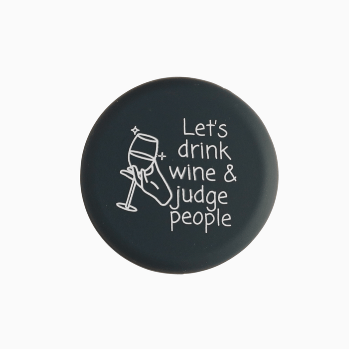 Silicone wine cap with the quote 'Let's drink wine & judge people' and a wine glass illustration.