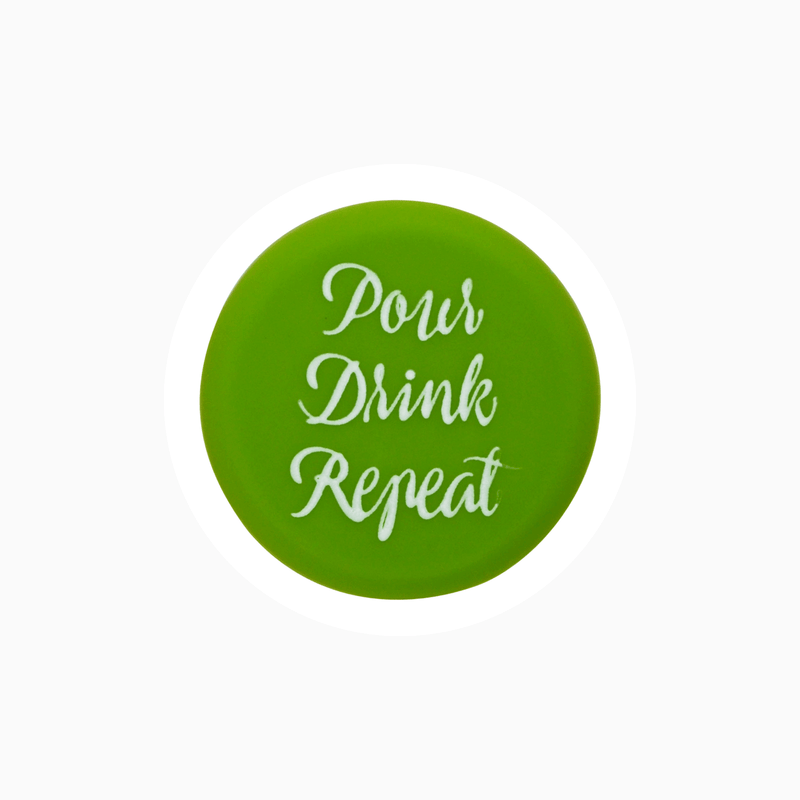 Green silicone wine cap with the text 'Pour Drink Repeat' for wine preservation.