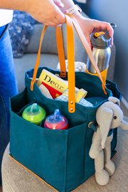 Petrol blue market tote with multiple pockets, holding water bottle, toys, and snacks, perfect for shopping and outings.