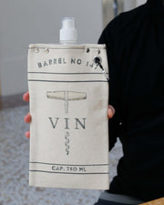 Vin Design 750ml canvas canteen with rugged cotton cover and wine bottle graphics held by a person.