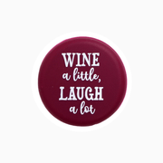 Silicone wine cap design featuring the phrase 'Wine a little, laugh a lot' in white text on a burgundy background.