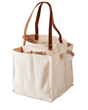 Natural multi-pocket canvas market tote with brown leather handles, ideal for organized shopping and carrying groceries.